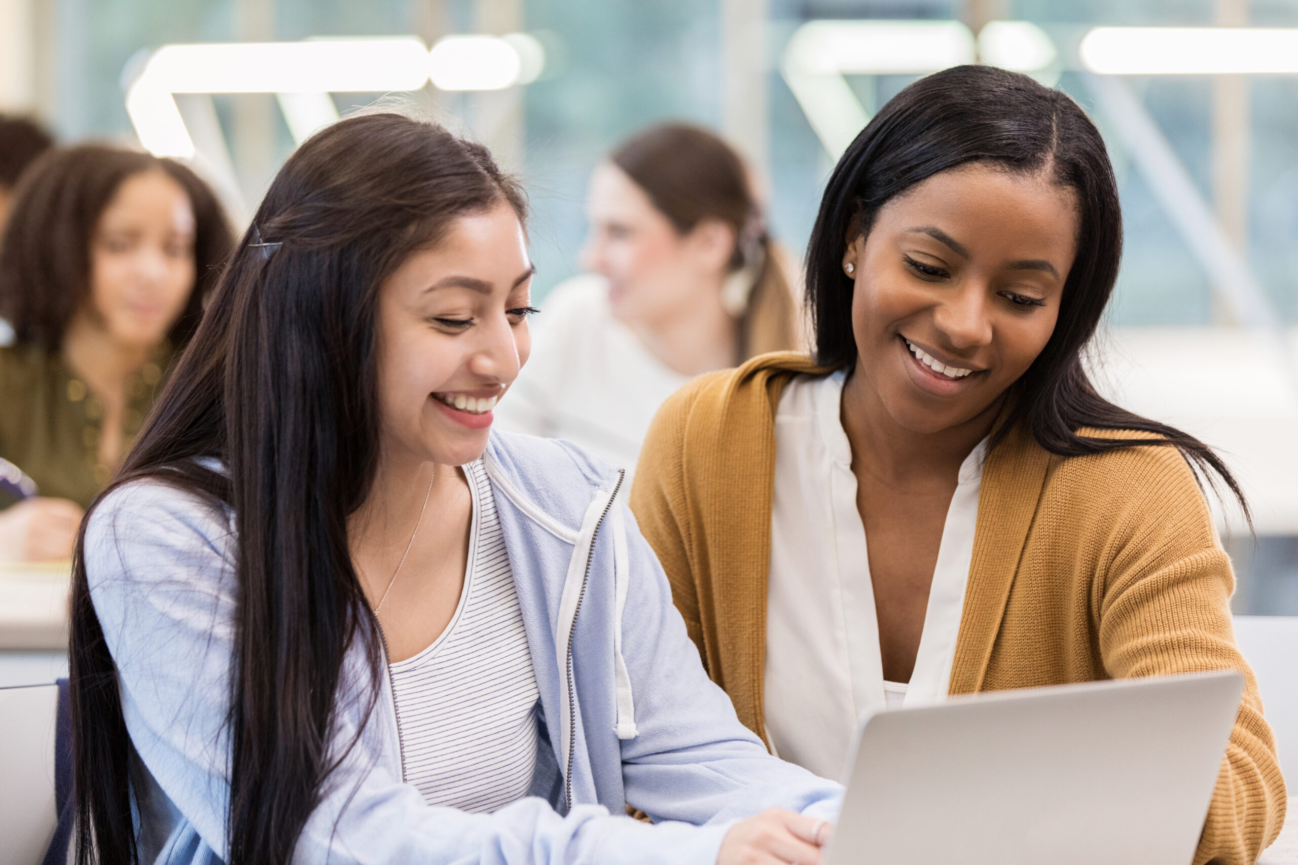 Mid adult African American tutor helps mixed race freshman